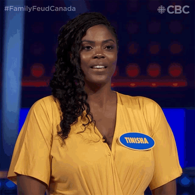 a woman wearing a yellow shirt with a name tag that says ' finisha ' on it