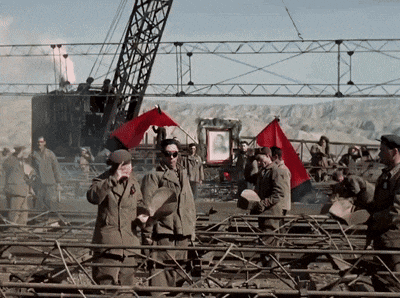 a group of soldiers are waving red flags in front of a picture