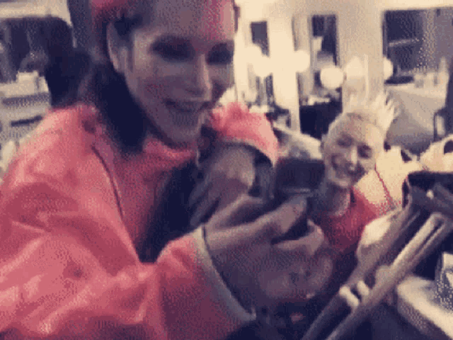 a woman in an orange raincoat is smiling while looking at her phone