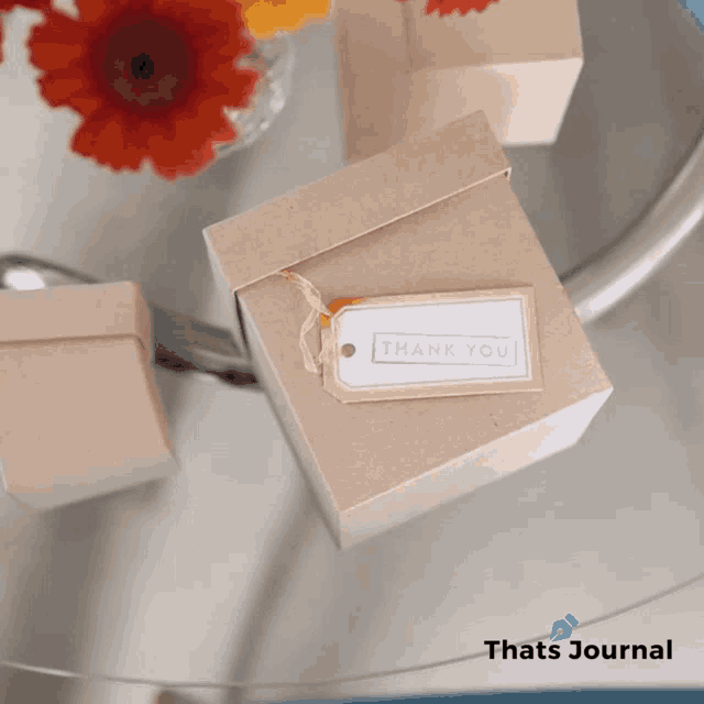a box with a thank you tag on it sits on a table