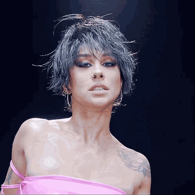 a woman with a tattoo on her chest and a pink top