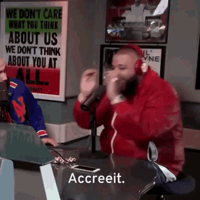 a man in a red jacket is singing into a microphone with the words accreeit on the bottom right