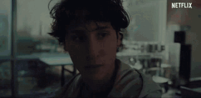 a close up of a young man 's face in a dark room with a netflix logo in the corner .