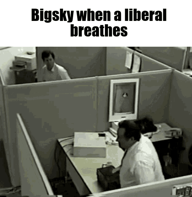 a man sitting at a desk with the words bigsky when a liberal breathes below him