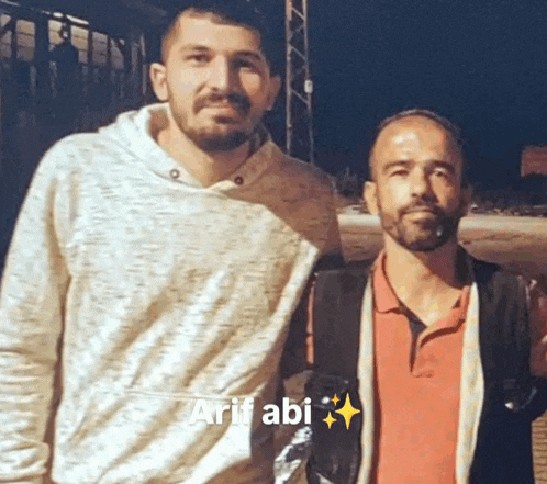 two men are posing for a picture and one of them has the name arif abi on it