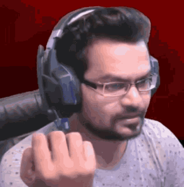 a man wearing headphones and glasses is making a middle finger gesture