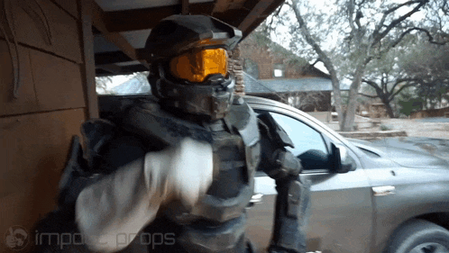 a man in a helmet and goggles is standing in front of a car with the words impecc props on the bottom