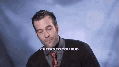 a man in a suit and tie is standing in front of a cloudy sky and says `` cheers to you bud '' .