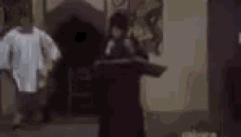 a blurry picture of a group of people sitting on a couch in a room .