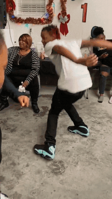 a group of people are dancing in a room with a number one on the wall