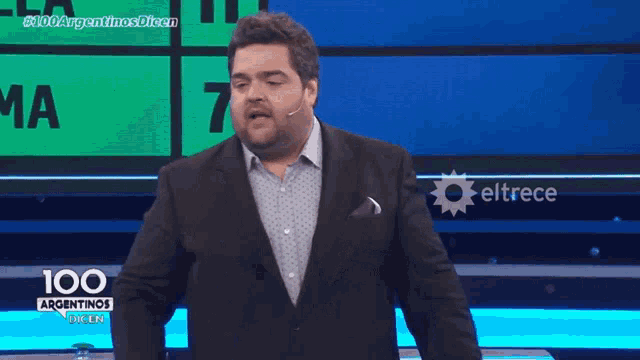 a man in a suit is holding a 100 argentinas card
