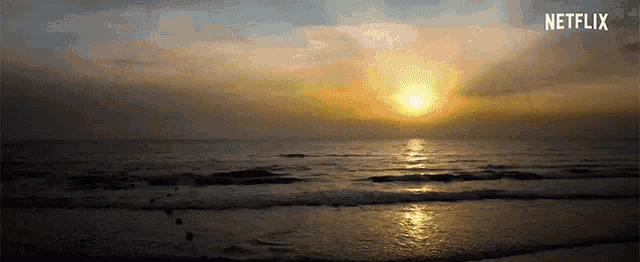 a sunset over the ocean with a netflix logo