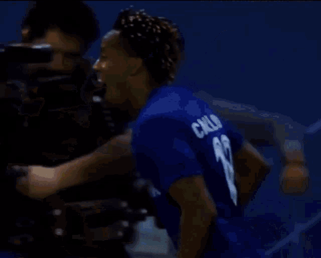 a man wearing a blue jersey with the number 19 on it is hugging another man