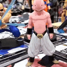 a figurine of buu from dragon ball z is standing on a table with other figurines .