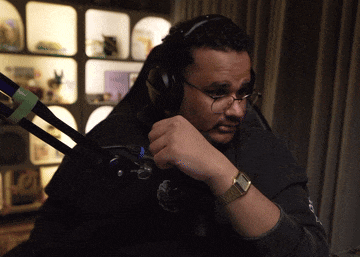 a man wearing headphones and a watch is sitting at a desk