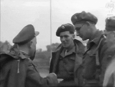 a group of soldiers are standing next to each other and talking .