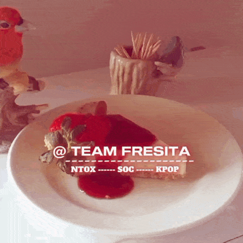 a white plate with a piece of cake on it with the words team fresita written on it