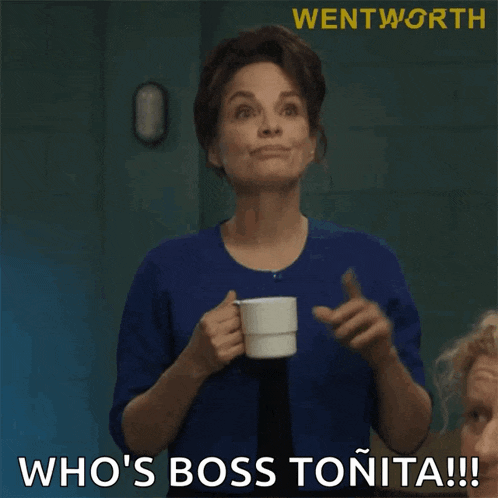 a woman in a blue shirt is holding a cup of coffee and saying i 'll show you