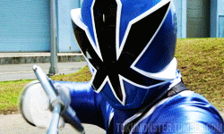 a blue power ranger is holding a sword in front of a sign that says tokyomonster.tumblr.com