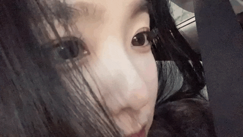 a close up of a woman 's face with long black hair looking at the camera .