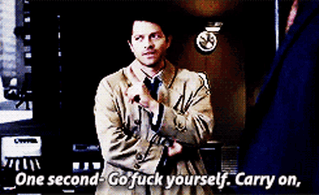 a man in a trench coat and tie says one second go fuck yourself carry on