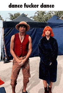 a man in a hat and a woman in a robe are standing next to each other .