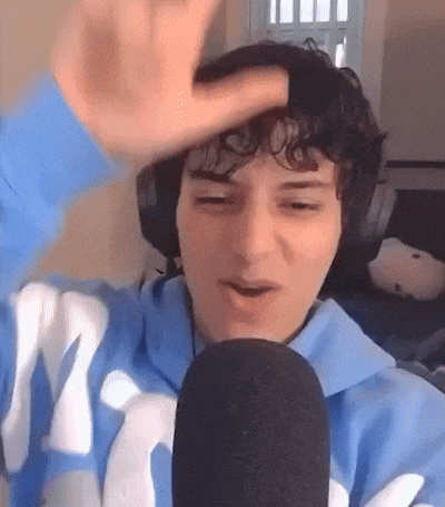 a person wearing headphones and a blue sweatshirt is talking into a microphone .