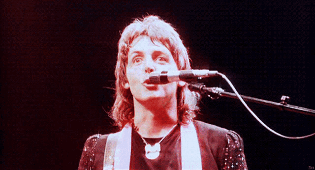 a man singing into a microphone with the letter t on the bottom