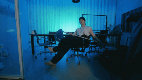 a man is sitting on a chair with his legs crossed