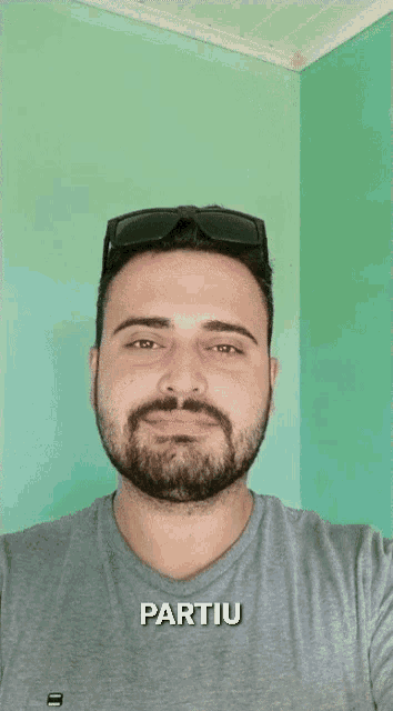 a man with a beard wearing sunglasses has partiu written on the bottom of his face