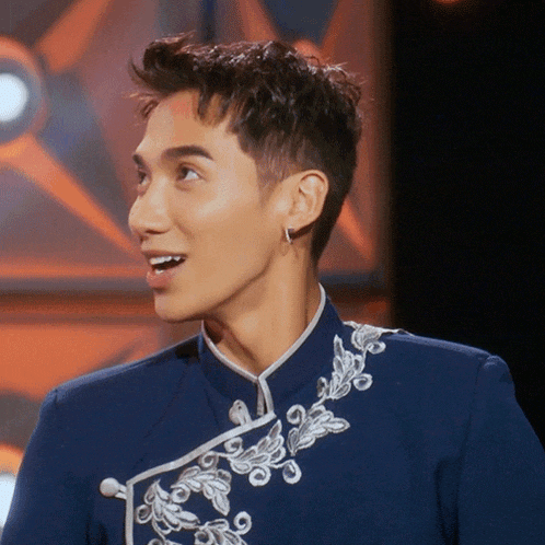 a man wearing a blue jacket with white embroidery on the collar