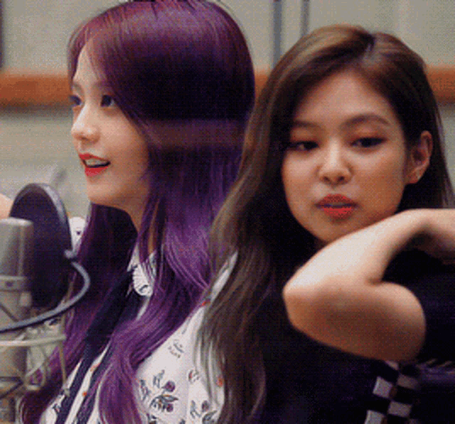 a woman with purple hair is standing next to another woman