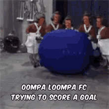 a group of people are standing around a blue ball that says oompa loompa fc trying to score a goal .