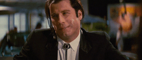 a man wearing a black suit and white shirt with a tie