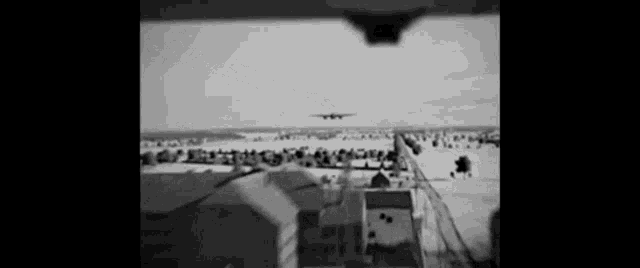 a black and white photo of a plane taking off
