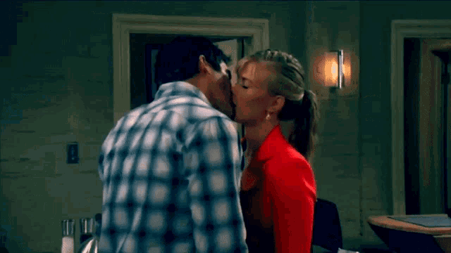 a man and woman are kissing in front of a door