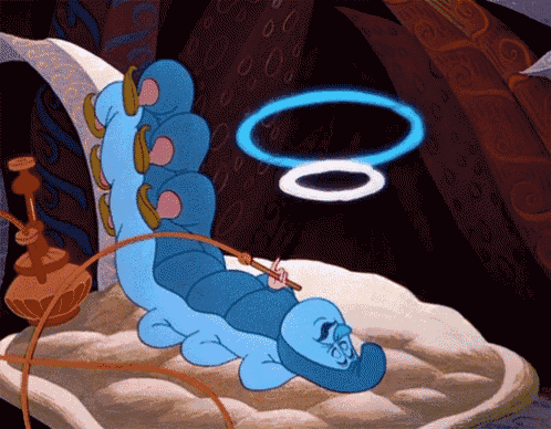 a blue caterpillar from alice in wonderland is laying on a cushion