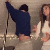 a man in a blue sweater is dancing with a woman in a white shirt