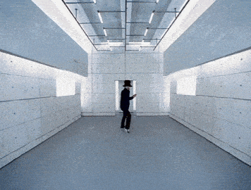 a man in a top hat is standing in a room with a lot of squares on the walls