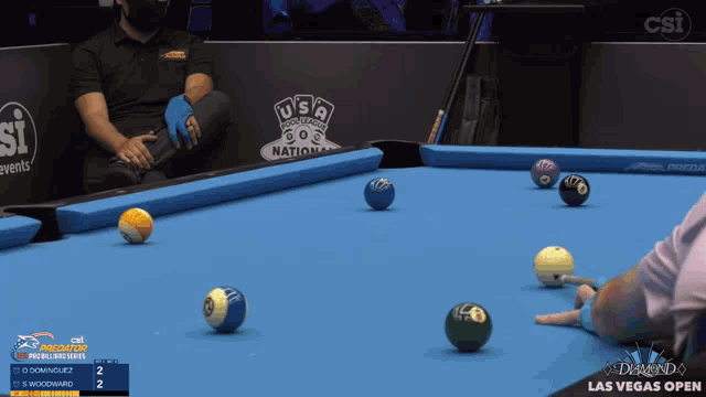 a pool table with a csi logo on the wall behind it
