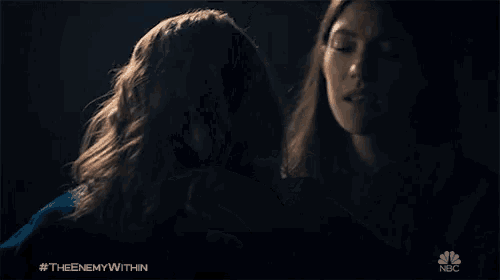 a woman hugging another woman with the hashtag #the enemywithin