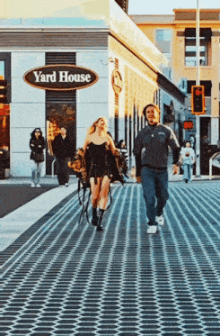 a man and a woman walking in front of a yard house