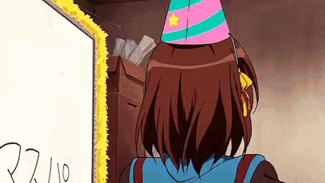 a girl in a party hat is standing in front of a white board .