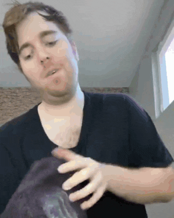 a man in a black shirt is holding a purple item in his hands .