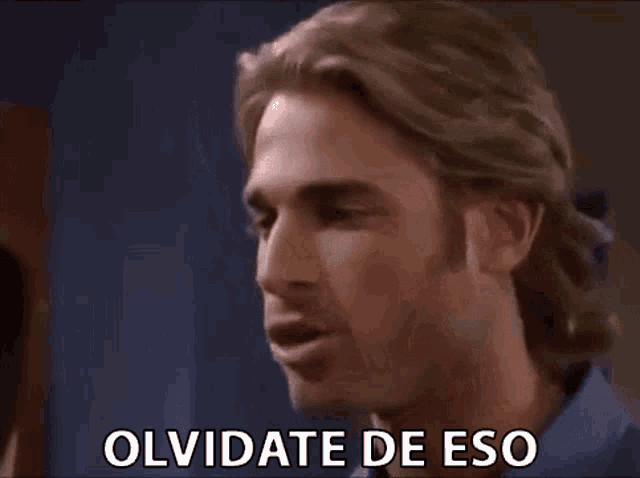 a close up of a man 's face with the words olvidate de eso written on it .