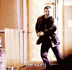a man is dancing in front of a door with the words oh yay written below him .
