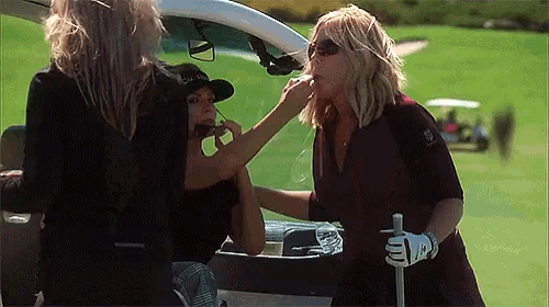 a woman is applying lipstick to another woman 's face