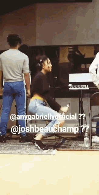 a woman in a black crop top and blue jeans is dancing in a room with a keyboard in the background