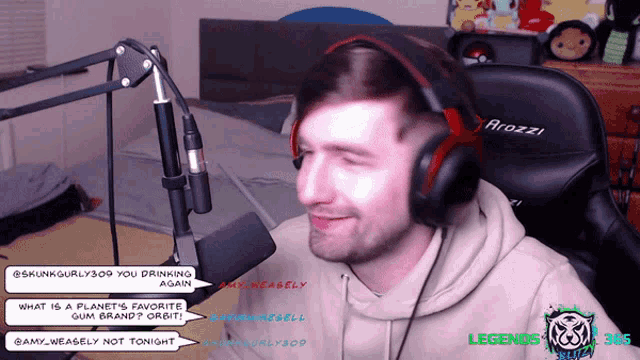 a man wearing headphones is sitting in front of a microphone and a chair that says atozzi