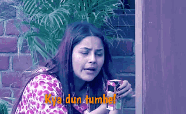a woman in a leopard print shirt is holding a can and the words kya dun tumhe are above her